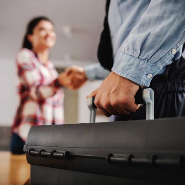 Closeup of a plumber's toolbox while he shakes hand with client