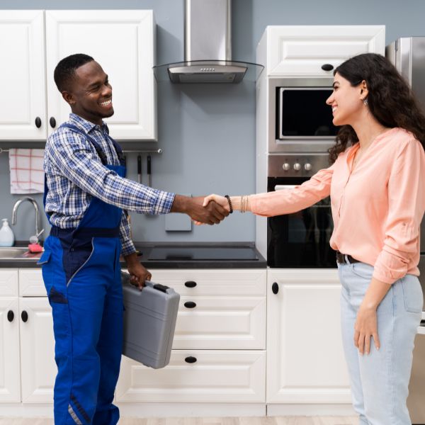 A plumber shaking hands with a happy client